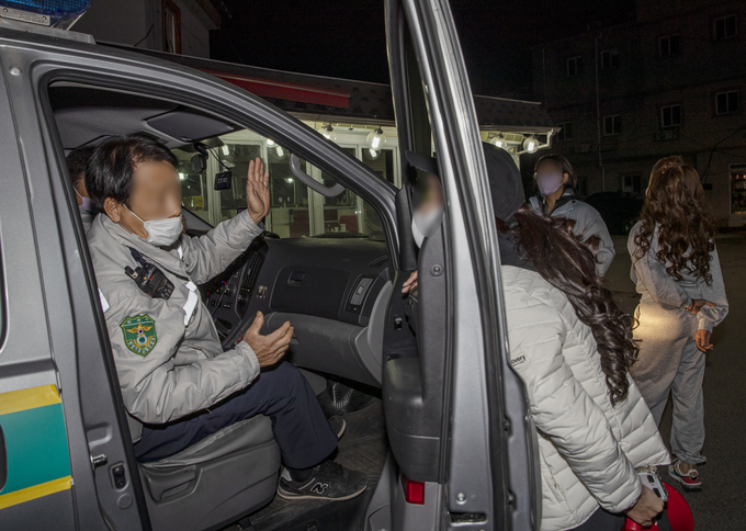 파주 연풍리 성매매집결지 종사자 모임 자작나무회 한 아무개 대표가 31일 밤 10시께 자율방범대 순찰차를 가로막고 경제적 어려움과 인권침해를 설명하고 있다. 사진 이용남 선임기자