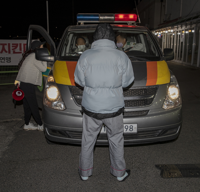 파주 연풍리 성매매집결지 종사자 모임 자작나무회(대표 한 아무개) 회원들이 31일 밤 10시께 자율방범대 순찰차를 가로막고 항의하고 있다. 사진 이용남 선임기자