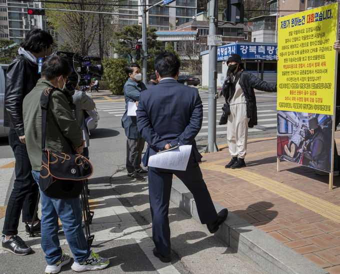 자작나무회 한 아무개 대표가 12일 파주시청 입구에서 김경일 파주시장의 성매매집결지 관련 긴급 기자회견에 참석한 기자들에게 1인 시위 배경을 설명하고 있다. 사진 이용남 선임기자 
