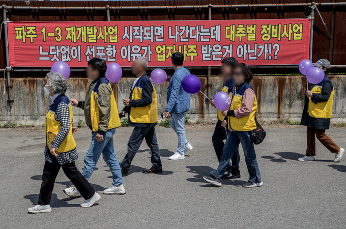 9일 파주시의 성매매집결지 해체를 위한 행복한 길 걷기 참가자들이 ‘파주 1-3 재개발사업 시작되면 나가겠다.’라는 펼침막이 걸린 집결지 골목울 행진하고 있다. 사진 이용남 선임기자