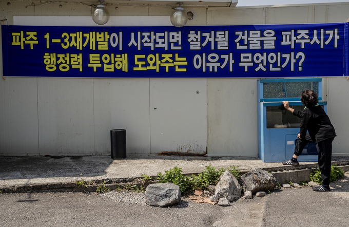 성매매집결지 사람들이 회의실로 사용하고 있는 정화위원회 사무실에 걸린 현수막을 집결지 노동자가 바라보고 있다. 사진 이용남 선임기자