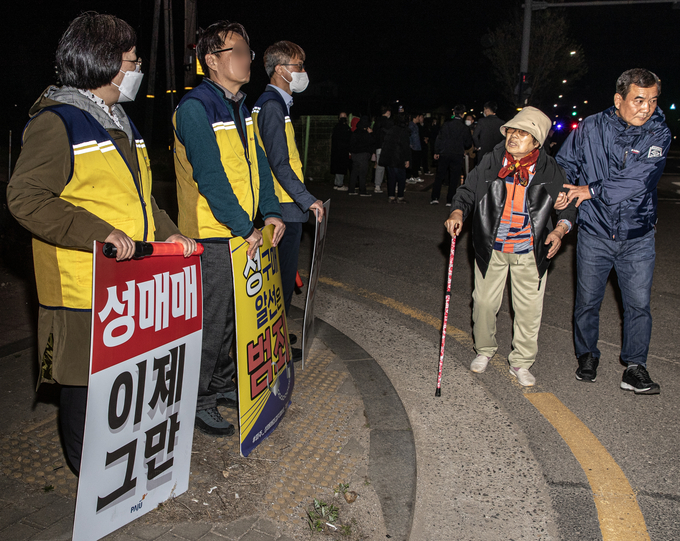 파주시의 성매수자 차단을 위한 올빼미 활동에 연풍2리 주민이 마을 이장의 부축을 받아 시끄러워 잠을 잘 수 없다며 항의하고 있다. 지난 19일 올빼미 활동은 밤 10시부터 새벽 1시까지 진행됐다. 사진 이용남 선임기자