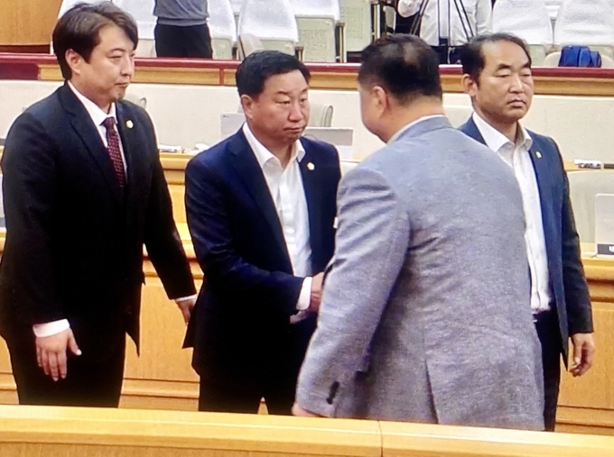 김경일 시장이 지난 14일 파주시의회 본회의장에서 예산 삭감에 격분 돌출행동을 한 후 국민의힘 원내대표 손형배 의원과 악수를 나누고 있다. 재선의 민주당 최유각 의원은 불쾌감을 감추지 않았다. 사진 파주바른신문 영상 캡쳐