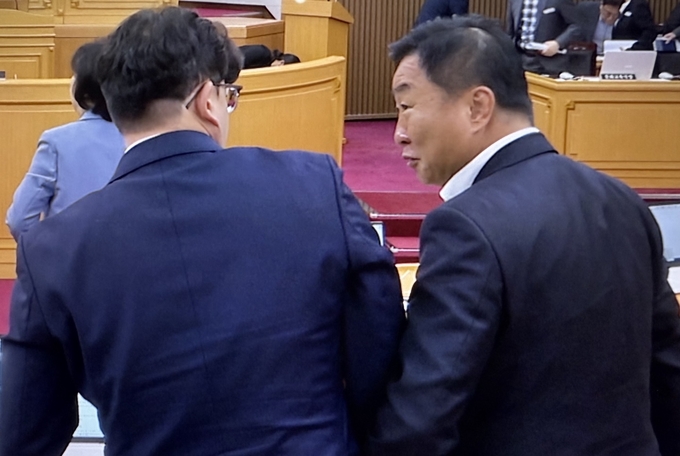 파주시의회 손형배(사진 오른쪽) 의원이 16일 열린 제155회 임시회 제2차 본회의에서 박대성 의장이 발의한 파주시 폐기물처리업체 선정 및 업무추진에 관한 행정사무조사 특별위원회 회의록 공개의 건에 대해 찬성표를 던진 후 목진혁(사진 왼쪽) 의원에게 웃음을 지어 보이고 있다. 사진 이용남 선임기자