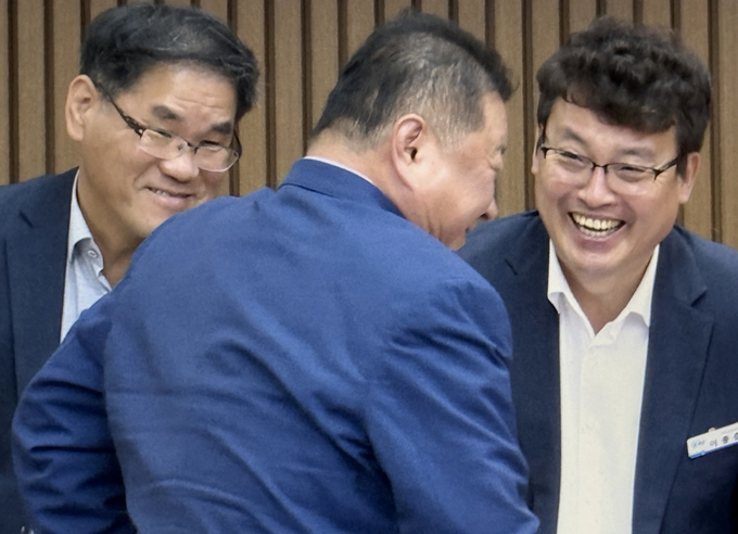 김경일 파주시장이 10일 파주시의회 정례회 제1차 본회의가 끝나자 집행부석에서 일어나 폴란드에 함께 동행하는 것으로 알려진 이종춘 재정경제실장(사진 오른쪽)과 웃음을 나누고 있다. 사진 이용남 선임기자