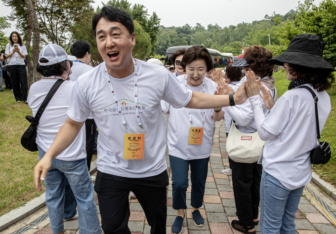 2025 한국입양인 평화대축제 운영위원인 손성익 파주시의원이 행사 첫날인 13일 입양인이 탄 관광버스가 엄마 품 동산에 도착하자 환영 세레머니를 하고 있다. 사진 조영애 기자